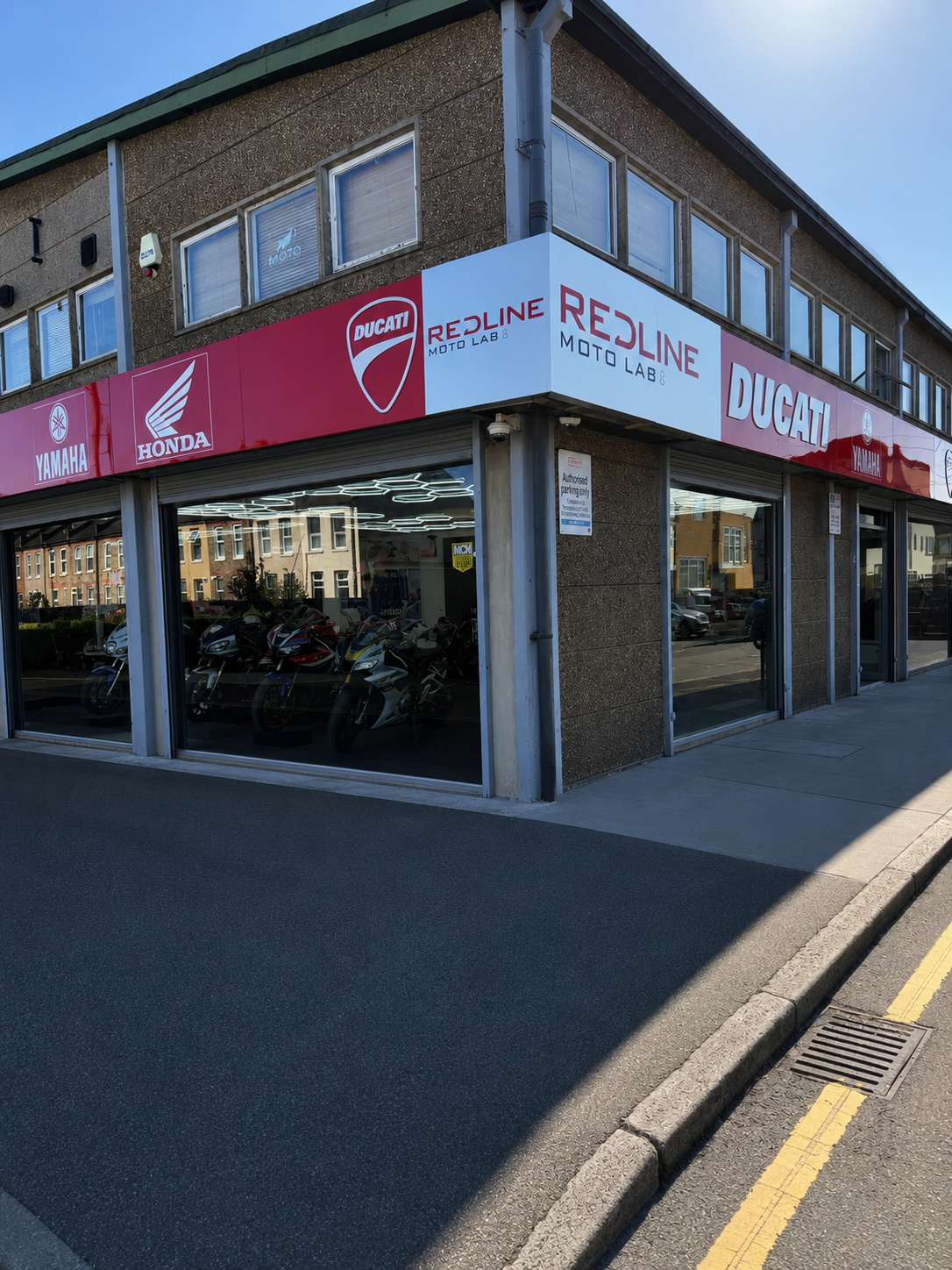 Redline MotoLab shopfront in Croydon with Ducati, Honda and Yamaha signage